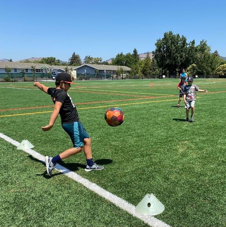 child kicking ball