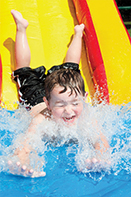 Young boy splashes into pool