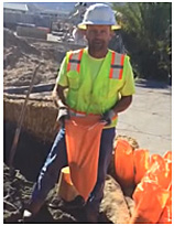 photo of maintenance worker filling sandbag